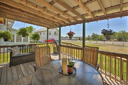 a patio with a glass table and chairs on a deck at Hot Springs Home - Walk to Oaklawn Casino! in Hot Springs