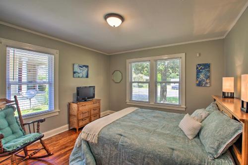 a bedroom with a bed and a desk and two windows at Hot Springs Home - Walk to Oaklawn Casino! in Hot Springs