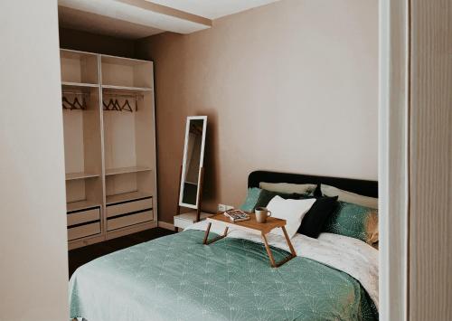 a bedroom with a bed with a table on it at S t r e h ë z a in Tirana