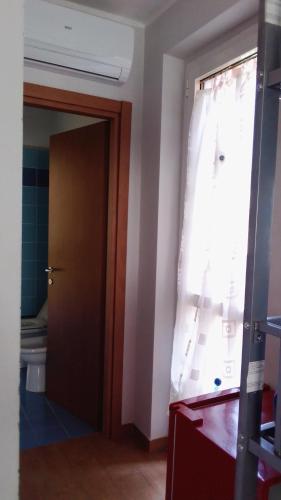 a bathroom with a door with a window and a toilet at La Quercia Fiorita in Trivolzio