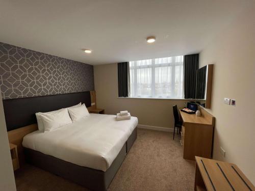 Best Western Northfields Ealing Hotel في لندن: غرفة في الفندق مع سرير ومكتب