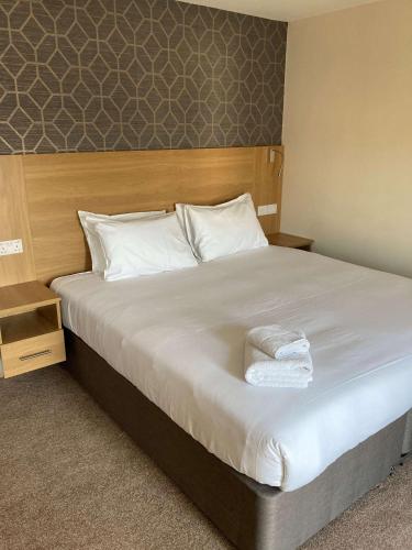 a bedroom with a large bed with white towels on it at Best Western Northfields Ealing Hotel in London