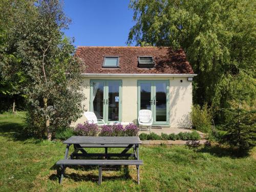a picnic table in front of a small house at The Pump-House in Chichester
