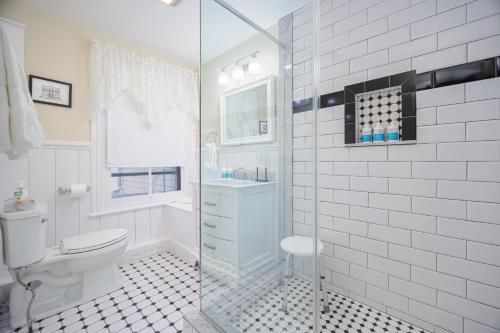 uma casa de banho com um WC e uma cabina de duche em vidro. em Bedford Inn em Cape May