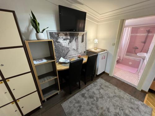 a room with a desk and a pink bathroom at Hostel Dino in Mostar