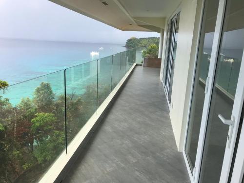 a balcony with a view of the ocean at Noor Villa - Luxury 3 Bed, 2 Bath Apartment with Stunning Panoramic Sea View, Private Beach in Pinamihagan
