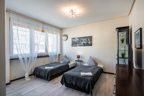 a bedroom with two beds and a window at 02 Gdynia Centrum - Apartament Mieszkanie dla 2 os in Gdynia