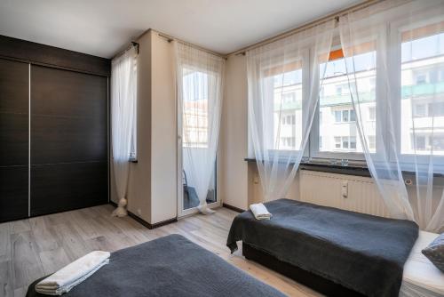 a bedroom with a bed and a large window at 02 Gdynia Centrum - Apartament Mieszkanie dla 2 os in Gdynia