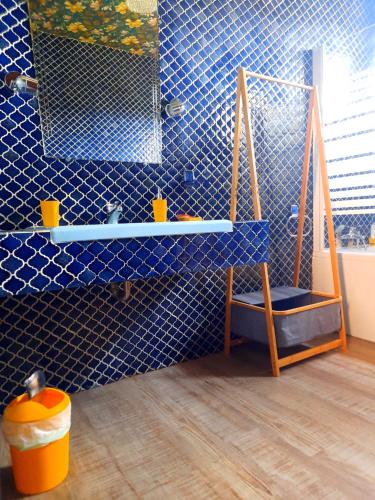 - une salle de bains carrelée de bleu avec une balançoire et un miroir dans l'établissement Domaine des Pins, à Saint-Estève