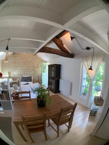 un salon avec une table et des chaises en bois dans l'établissement Appart chic et cosy/centre ville/ 20min de Paris, à Maisons-Laffitte