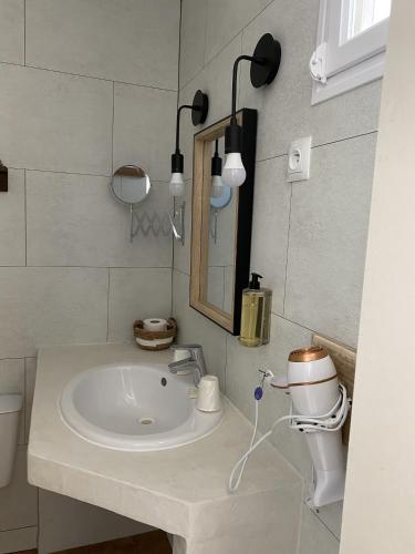 a bathroom with a sink and a mirror at Hôtel du Pont Blanc in Saintes-Maries-de-la-Mer