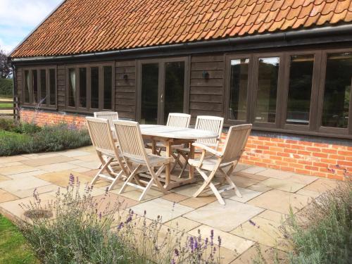 a table and chairs sitting on a patio at The Coach House Barn - Valley Farm in Sudbourne