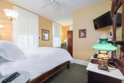 a bedroom with a bed and a green lamp on a table at Bedford Inn in Cape May