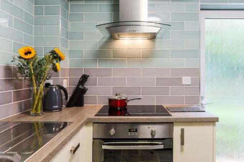 una cucina con piano cottura e vaso di fiori di Truro apartment in a stunning quiet location a Truro