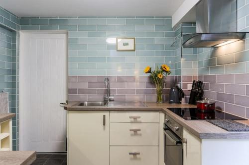 una cucina con lavandino e vaso di fiori di Truro apartment in a stunning quiet location a Truro