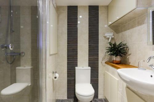 a bathroom with a toilet and a sink and a shower at Truro apartment in a stunning quiet location in Truro