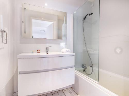 une salle de bain blanche avec un lavabo et une douche dans l'établissement Apartment Soleil Bleu-8 by Interhome, à Canet