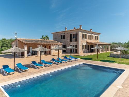 a villa with a swimming pool in front of a house at Holiday Home Casa Eva - SSS130 by Interhome in Ses Salines