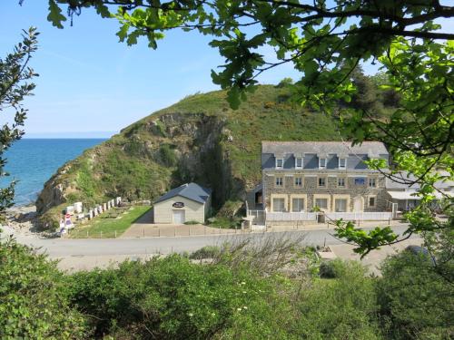 a large building on a hill next to the ocean at Apartment Les Sternes - PGX304 by Interhome in Planguenoual