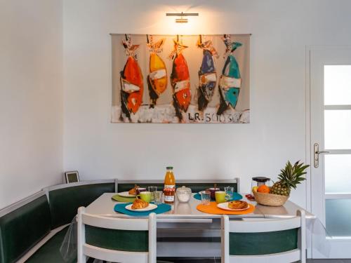 プランゲヌアルにあるHoliday Home Valhalla- chez Jules by Interhomeのダイニングルーム(テーブル、椅子、サーフボードの写真付)