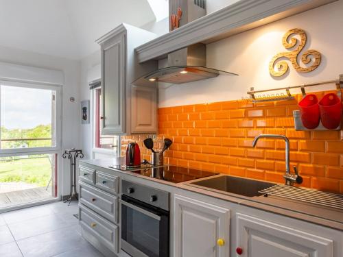 - une cuisine avec un évier et un mur en brique orange dans l'établissement Holiday Home Valhalla- chez Jules by Interhome, à Planguenoual