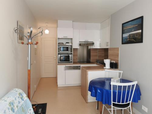 a small kitchen with a blue table in a room at Apartment Le Vieux Port by Interhome in Cancale