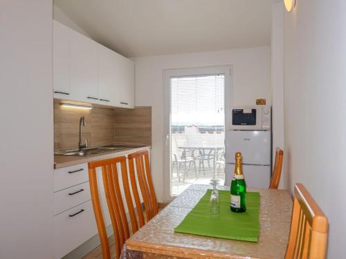 kuchnia ze stołem i butelką wina w obiekcie Apartment Barbara-2 by Interhome w mieście Punat