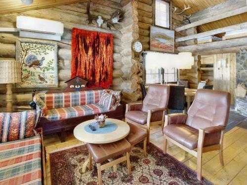ein Wohnzimmer mit einem Sofa und Stühlen in einer Blockhütte in der Unterkunft Holiday Home Hankisääski by Interhome in Ylläsjärvi