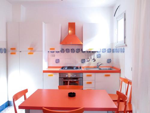 a kitchen with a red table and a red stove at Apartment Bellavista 6 by Interhome in Cattolica