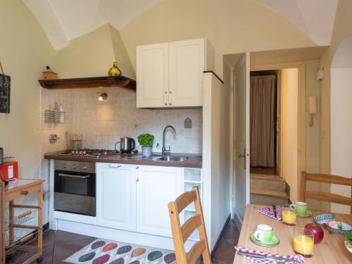 eine kleine Küche mit weißen Schränken, einem Tisch und einem Siddx-Tisch in der Unterkunft Apartment Ca' du Mou - DOL102 by Interhome in Dolcedo