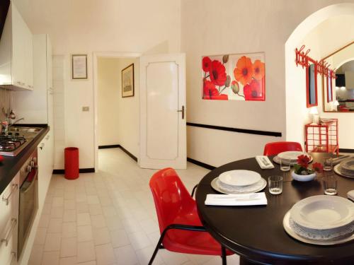 uma cozinha com uma mesa preta e cadeiras vermelhas em Apartment Bellavista-4 by Interhome em Cattolica