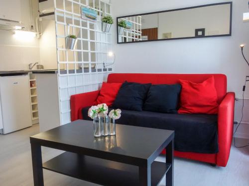 a living room with a red couch and a table at Apartment Les Trois Mousquetaires by Interhome in Saint-Palais-sur-Mer