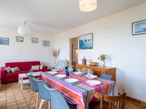 - une salle à manger avec une table, des chaises et un canapé rouge dans l'établissement Villa Trezen by Interhome, à Carnac