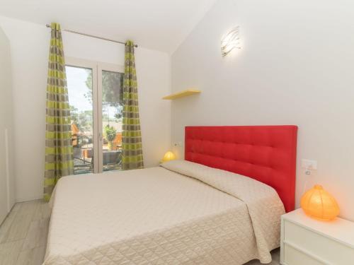 a bedroom with a large bed with a red headboard at Holiday Home San Pietro Blue by Interhome in Codaruina
