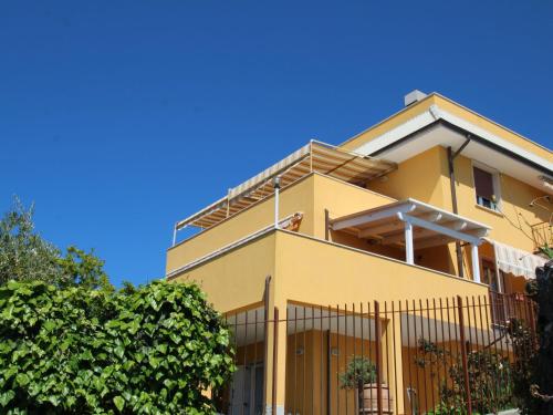 una casa gialla con un cielo blu sullo sfondo di Apartment Orizzonte by Interhome a Moneglia
