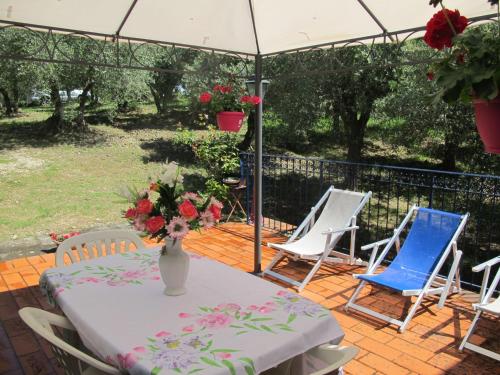 una mesa con sillas y un jarrón de flores en el patio en Apartment Conte Francesco II-5 by Interhome, en Certaldo