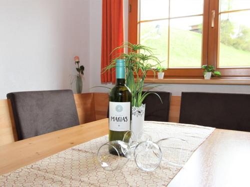 een fles wijn op een tafel met glazen bij Apartment Alpin by Interhome in Hainzenberg