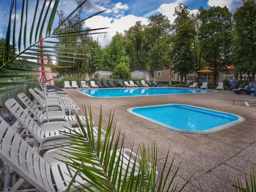 a group of white chairs and a swimming pool at Holiday Home Sunset Terrace by Interhome in Prague
