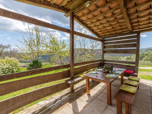 a wooden porch with a table and a bench at Holiday Home Podere Casidote by Interhome in Montieri
