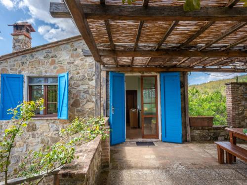 a stone house with blue doors and a wooden roof at Holiday Home Podere Casidote by Interhome in Montieri