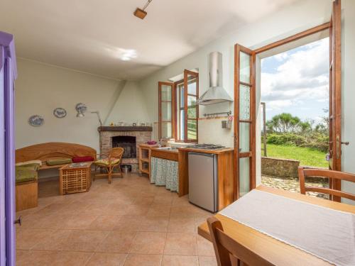 a kitchen and living room with a table and a fireplace at Holiday Home Podere Casidote by Interhome in Montieri