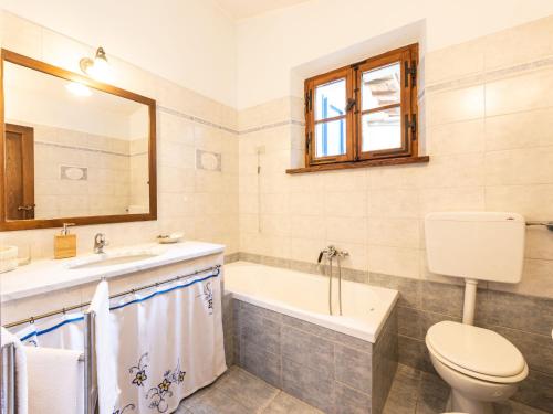 a bathroom with a toilet and a tub and a sink at Holiday Home Podere Casidote by Interhome in Montieri