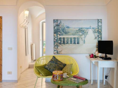 a living room with a yellow chair and a table at Holiday Home Francesca - SLR212 by Interhome in Cipressa
