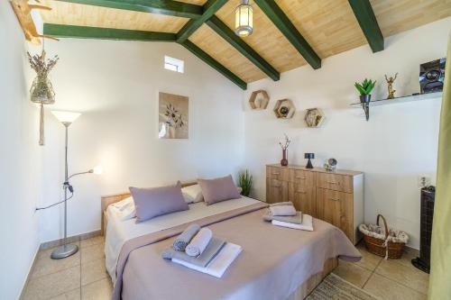 a bedroom with a bed with towels on it at Holliday Home "Maslinada" in Milna