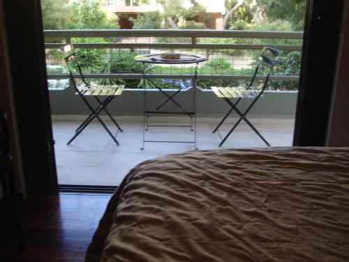 a bedroom with two chairs and a table on a balcony at Amazing Apartment in Athens