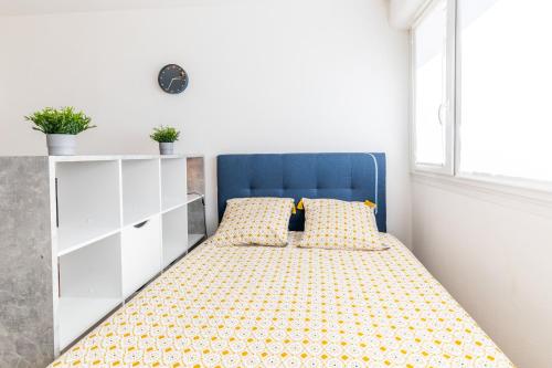 a bedroom with a bed with a blue headboard at La fée verte in Pontarlier