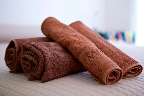 três toalhas castanhas em cima de uma cama em Home40 em San Salvo