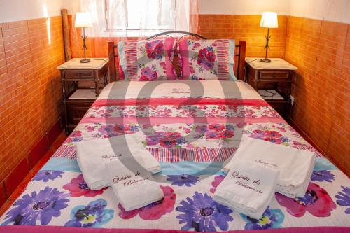 ein Bett mit Handtüchern und Kissen darauf mit zwei Tischen in der Unterkunft Quinta de Belmonte in Estremoz