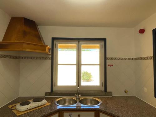 a kitchen with a sink and a window at HI Oeiras – Pousada de Juventude in Oeiras