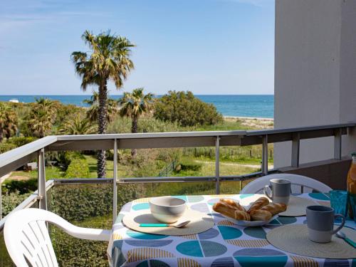 - une table avec des croissants sur un balcon donnant sur l'océan dans l'établissement Apartment Les Capitelles-9 by Interhome, à Saint Cyprien Plage